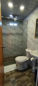 a bathroom with a toilet and a sink at La Cabañita VIP Amanecer in Minca