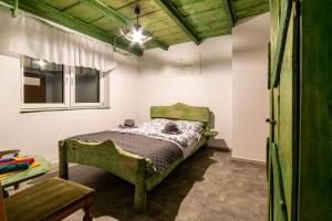 a bedroom with a green bed and a window at Agroturystyka Gościniec Ethoria in Łomnica