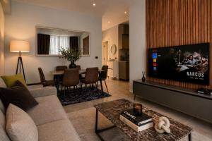 a living room with a couch and a flat screen tv at Green Coast Escape in Palasë