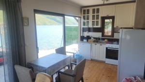 a kitchen with a table and a view of the water at Kuca za odmor Labud in Donji Milanovac