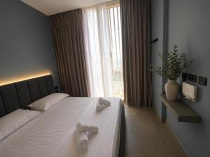 a bedroom with a large bed with two towels on it at Green Coast Escape in Palasë