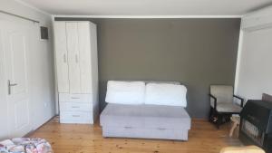 a living room with a bed and a dresser and a room at Kuca za odmor Labud in Donji Milanovac