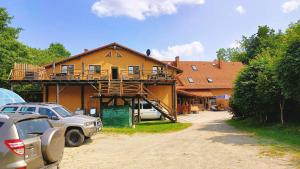 a house with a balcony on the side of it at Agroturystyka Gościniec Ethoria in Łomnica