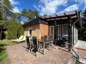 a patio with a table and chairs and a grill at Ferienhaus Fjola in Schenkendöbern