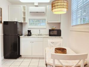 a kitchen with white cabinets and a black refrigerator at Blackfin Resort and Marina in Marathon