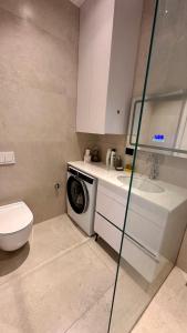 a bathroom with a washing machine and a sink at Green Coast Escape in Palasë +10 photos