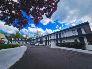 a building with a car parked in front of it at Penn Lodge Hotel & Suites Philadelphia - Bensalem in Bensalem