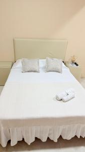 a white bed with two pillows and two towels on it at APART LyM 2 in Clorinda