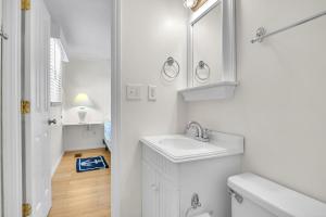 a white bathroom with a sink and a mirror at Sunkissed 2 by Oak Island Accommodations in Oak Island