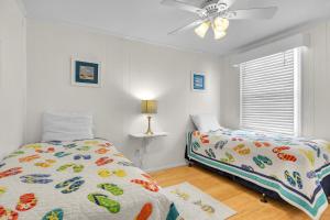 a bedroom with two beds and a ceiling fan at Sunkissed 2 by Oak Island Accommodations in Oak Island