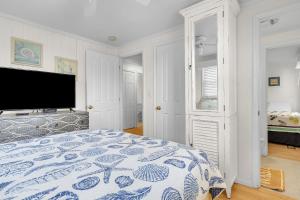 a bedroom with a bed and a flat screen tv at Sunkissed 2 by Oak Island Accommodations in Oak Island +10 photos
