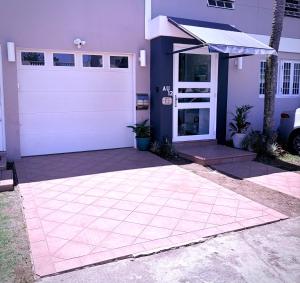 a garage with a white door and a purple house at Escape Caribeño in Levittown