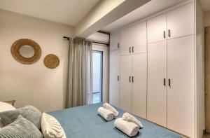a bedroom with a bed and white cabinets at Eftychia's Cozy Apartment in Sitia