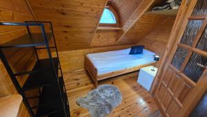 a small room with a bed and a ladder at Domek przy stajni in Wielki Głęboczek