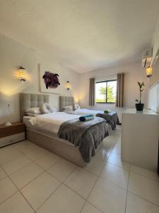 a large bedroom with two beds and a window at Casa Julio-Rooftop Terrace & Pool 5 Min to Beach in Carvoeiro