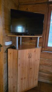 a television on top of a wooden cabinet in a room at Domek przy stajni in Wielki Głęboczek