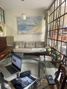 a living room with a glass table with a laptop at Loft Junín in Junín