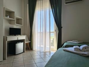 a bedroom with two beds and a television and a window at Il Quadrifoglio in Frascineto