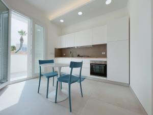 a kitchen with a table and two blue chairs at La Casa sulla Spiaggia Torre San Giovanni - Coste del Sud it in Torre San Giovanni Ugento