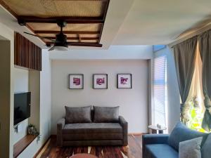 a living room with a couch and a tv at Musa Hotel Boutique in Bucerías