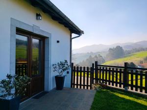 a house with a wooden door and a fence at MINI PICONEIRO II in Pravia