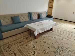 a living room with a blue couch and a coffee table at Sayora Guest House in Khorugh