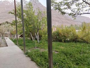 a sidewalk next to a field with a mountain at Sayora Guest House in Khorugh