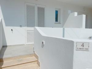 a white room with a staircase and a door at La Casa sulla Spiaggia Torre San Giovanni - Coste del Sud it in Torre San Giovanni Ugento