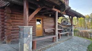 a log cabin with a bench on a porch at Domek przy stajni in Wielki Głęboczek