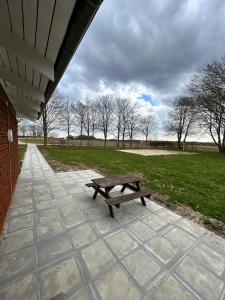 a picnic bench sitting on a patio in a park at Overnatning med plads til mange in Holstebro