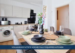 a kitchen with a table with bowls and plates on it at RtR Essen - Für bis zu 8 Personen - Voll ausgestattet - Zentral Limbecker Platz - Messe - Uniklinikum - Smart TV - Modern in Essen +11 photos