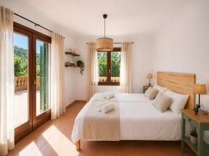 a white bedroom with a bed and a balcony at Son Grau in Alaró +22 photos