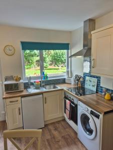 a kitchen with a washing machine and a sink at Guest Suite in County Limerick in Pallaskenry