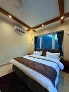 a large bed in a room with a large window at Kesari Hotel & Restaurant Near Kainchi Dham in Rāmgarh