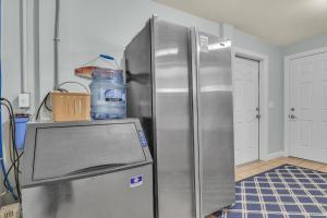 a stainless steel refrigerator with a bottle of water on top at Surviving Stress by Oak Island Accommodations in Caswell Beach