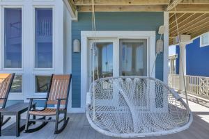 a porch with two chairs and a white swing at Surviving Stress by Oak Island Accommodations in Caswell Beach