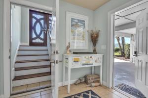 a hallway with a staircase and a door leading to a house at Surviving Stress by Oak Island Accommodations in Caswell Beach