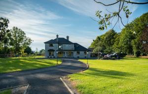 a large white house with a driveway at Guest Suite in County Limerick in Pallaskenry