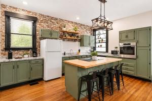 a kitchen with green cabinets and a white refrigerator at Cozy Home near Downtown - Close to Nulu - Sleeps 6 in Louisville