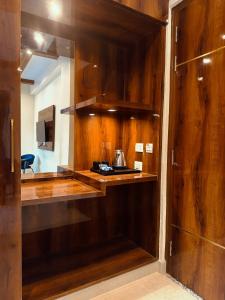a kitchen with wooden walls and a counter with a coffee maker at Kesari Hotel & Restaurant Near Kainchi Dham in Rāmgarh