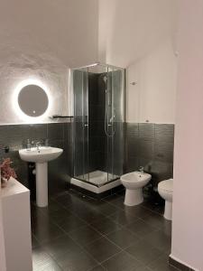 a bathroom with two sinks and a shower and a toilet at Atenè Rooms in Agrigento +29 photos
