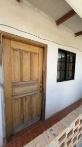 a wooden door on a white wall with a window at Accommodation in Copán Ruinas #5 in Copán Ruinas +6 photos