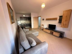 a large living room with a couch and a tv at Endi Apartments 2 in Tirana +1 photo