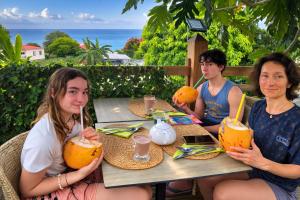 a group of people sitting at a table with drinks at Tidododesiles in Bouillante