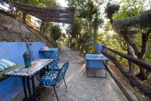 a row of tables and chairs on a patio with trees at Alojamiento Rural El Brazal in Lanjarón