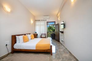 a bedroom with a bed and a tv in it at Kandy Neela Weralu in Haragama