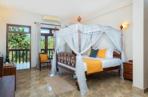 a bedroom with a bed with a canopy at Kandy Neela Weralu in Haragama