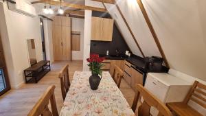 a kitchen with a table with a vase of flowers on it at Domek Julia in Krościenko