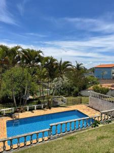 a swimming pool in a yard with palm trees at Farm km 68 Castelo Branco in Mairinque +6 photos