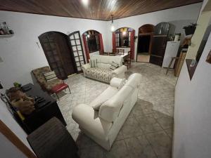 a living room with white couches and a kitchen at Farm km 68 Castelo Branco in Mairinque
